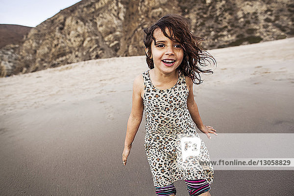 Glückliches Mädchen genießt am Strand am Ufer