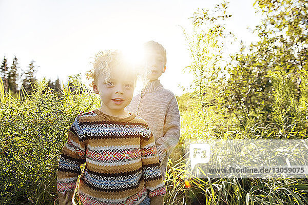 Portrait of boy with brother on grassy field