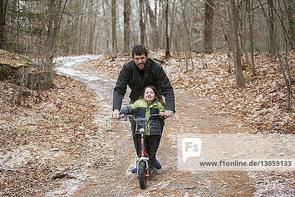 Porträt von Vater und Sohn beim Rollerfahren auf der Strasse im Winter
