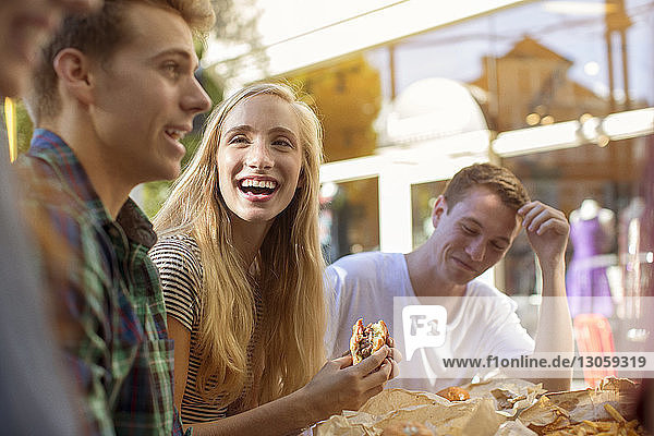 Happy friends eating at sidewalk cafe