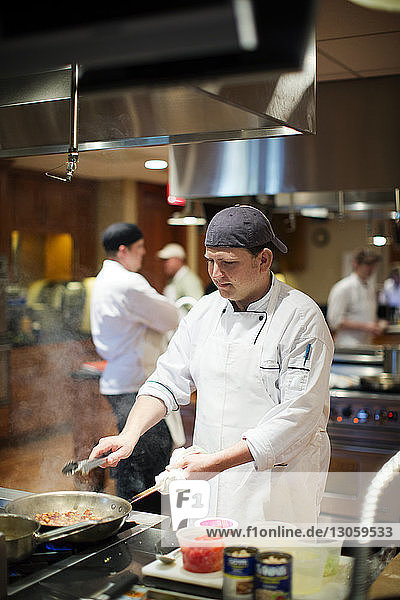 Chef cooking food in commercial kitchen