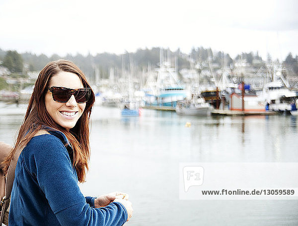Lächelnde Frau steht auf Schiff auf See