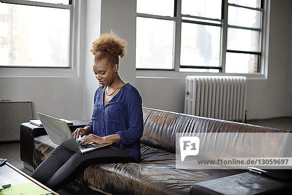 Businesswoman using laptop in creative office
