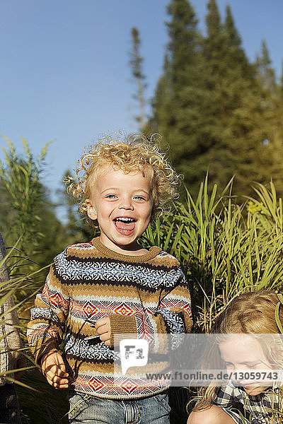 Porträt eines glücklichen Jungen mit Schwester auf dem Feld