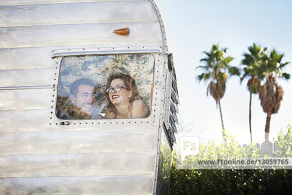 Glückliches Paar schaut durchs Fenster  während es im Wohnmobil sitzt