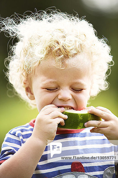 Junge mit lockigem Haar genießt Wassermelone