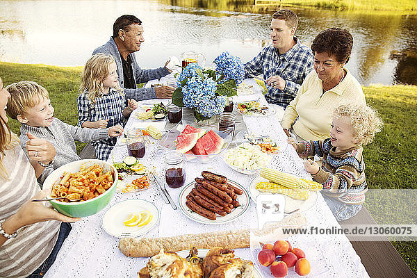 Hochwinkelansicht einer Mehrgenerationen-Familie  die auf einem Picknicktisch sitzt