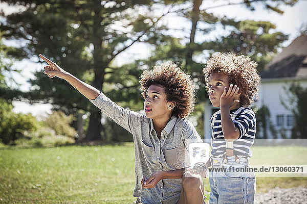 Girl pointing to brother at backyard