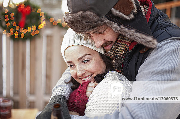 Close-up of smiling couple embracing outdoors