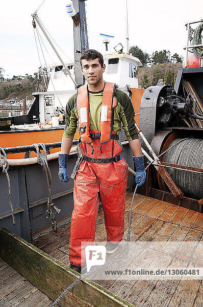 Portrait of young man standing on fishing boat