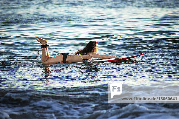 Seitenansicht einer Frau beim Surfen im Meer
