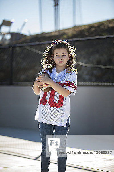 Porträt eines Mädchens  das an einem sonnigen Tag Fussball hält