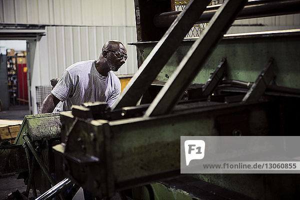 Schwerer Arbeiter an Maschinen in der Metallindustrie