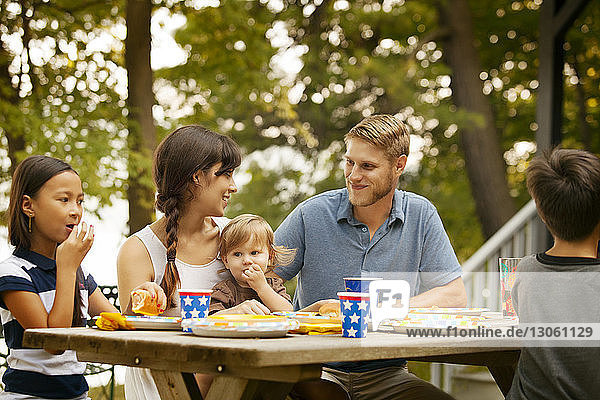 Familie und Freunde beim Essen am Picknicktisch