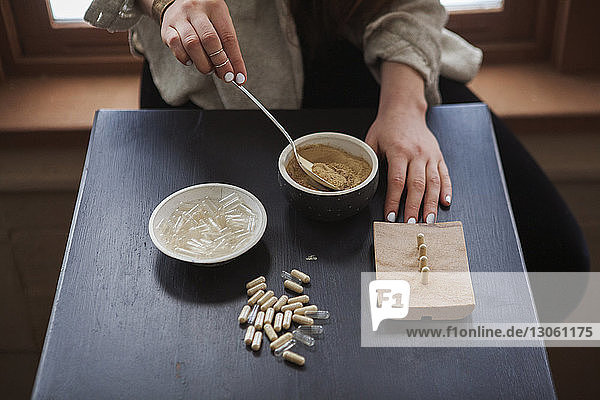 Midsection of woman making herbal medicines at home