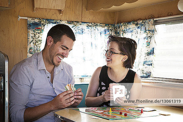 Glückliches Paar spielt Brettspiel  während es im Wohnmobil sitzt