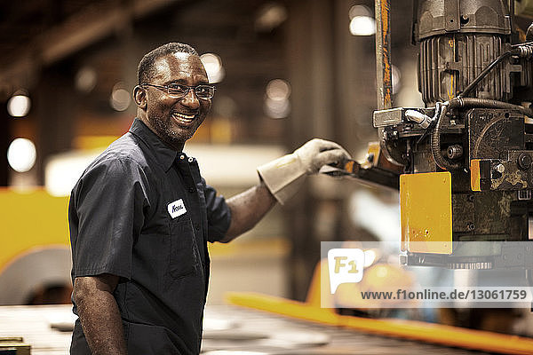 Porträt eines Arbeiters  der an Maschinen in der Metallindustrie arbeitet