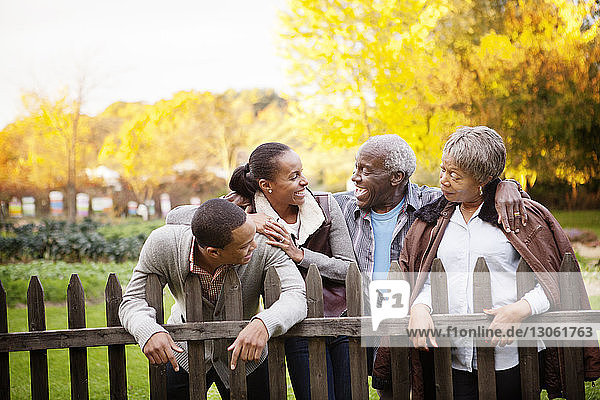 Happy family standing by fence