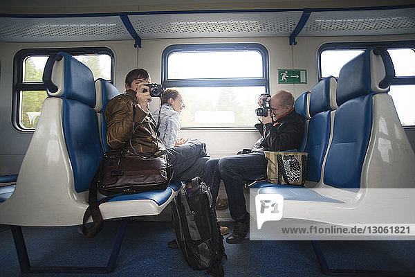 Freunde fotografieren während der Zugfahrt