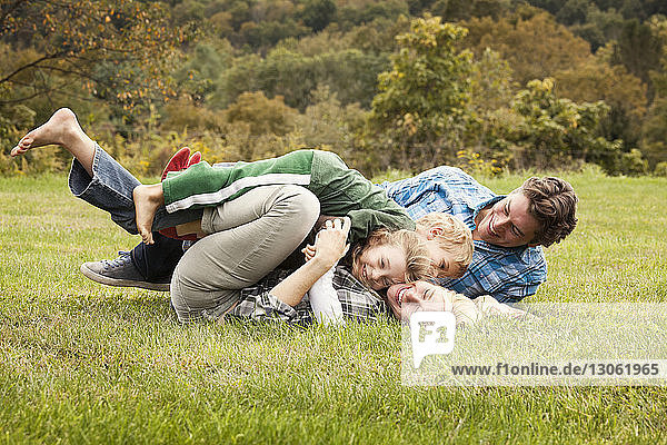 Playful family embracing on grassy field