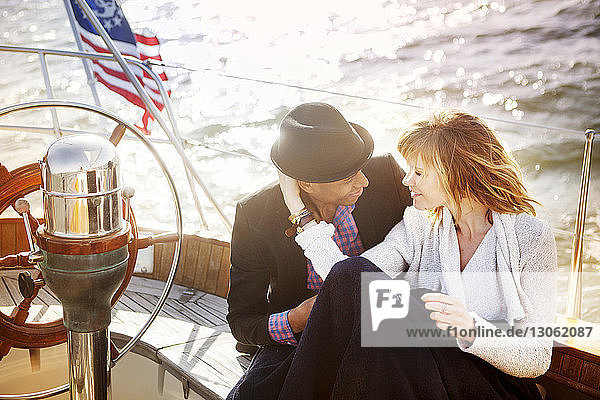 Glückliches Paar sitzt an Deck einer Yacht