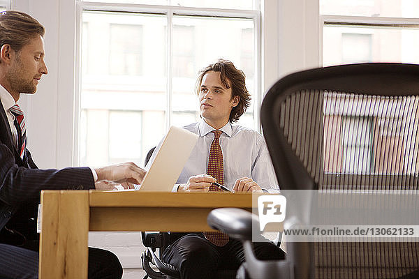 Businessmen sitting at table in office