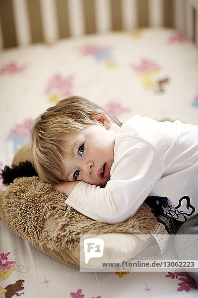 Porträt eines Jungen  der sich zu Hause auf einer Krippe ausruht