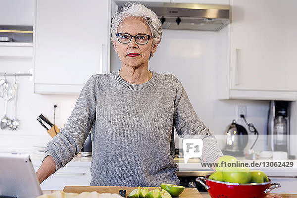 Porträt einer selbstbewussten Frau  die in der Küche steht
