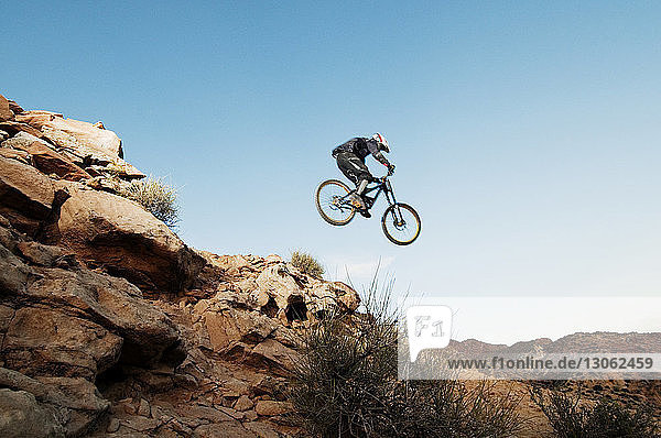 Niedrigwinkelansicht eines Mountainbikers bei einem Stunt in der Luft