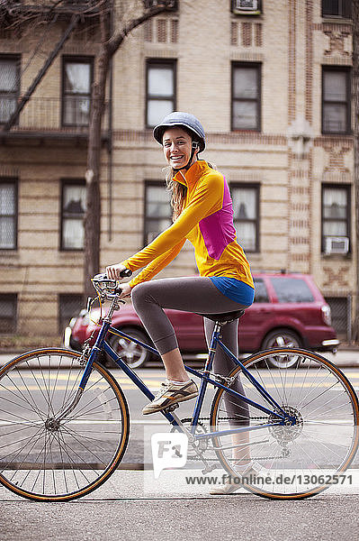 Porträt einer Radfahrerin mit Fahrrad auf einem Fußweg