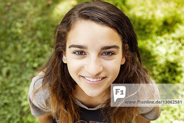 Porträt eines fröhlichen Teenager-Mädchens auf Grasfeld stehend