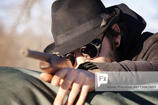 Close-up of man aiming rifle