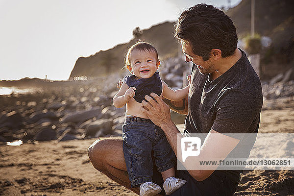 Vater mit fröhlichem Jungen am Strand