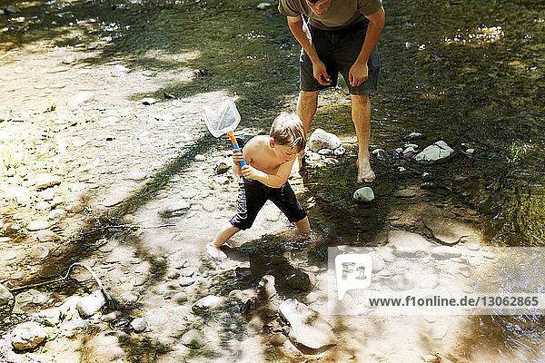 High angle view of father and son fishing using net in river