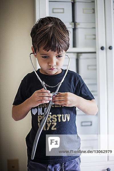 Junge benutzt Stethoskop  während er zu Hause steht