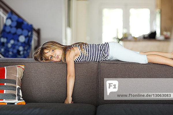 Porträt eines gelangweilten Mädchens  das zu Hause auf dem Sofa liegt