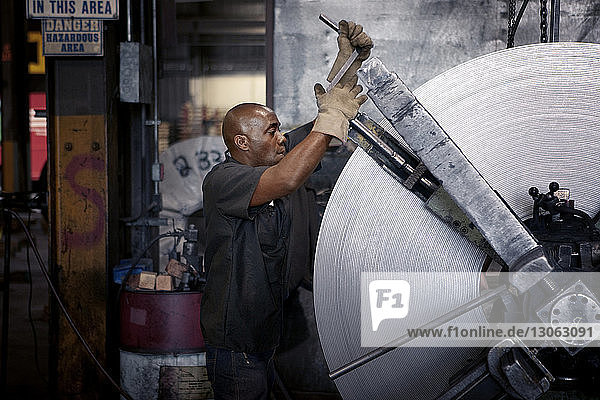 Seitenansicht des Menschen bei der Benutzung von Maschinen in der Metallindustrie