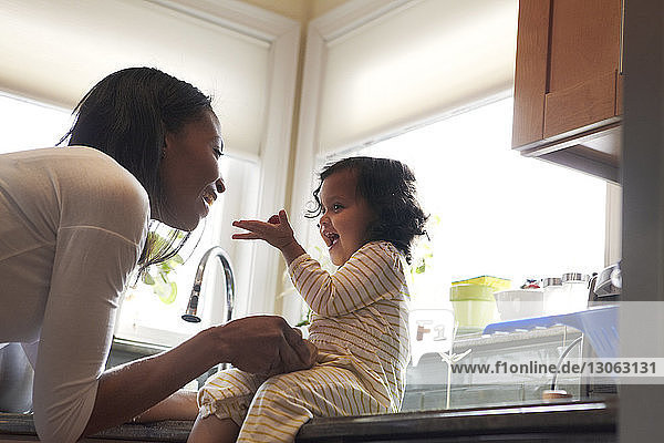 Mother and daughter playing in kitchen