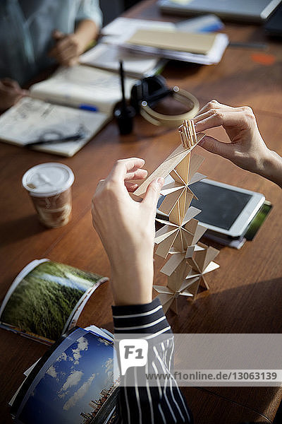 Ausgeschnittenes Bild einer Geschäftsfrau  die bei Tisch ein Kunstprodukt herstellt