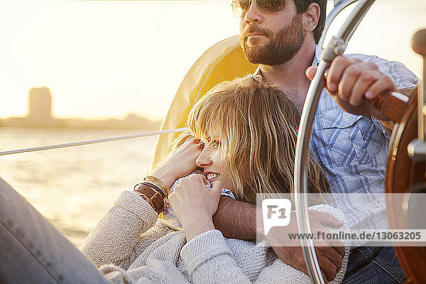 Ehepaar sitzt bei Sonnenuntergang auf einer Yacht