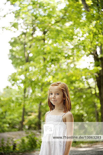 Porträt eines lächelnden Mädchens vor Bäumen im Wald