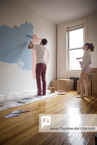 Frau betrachtet Freund beim Malen an der Wand