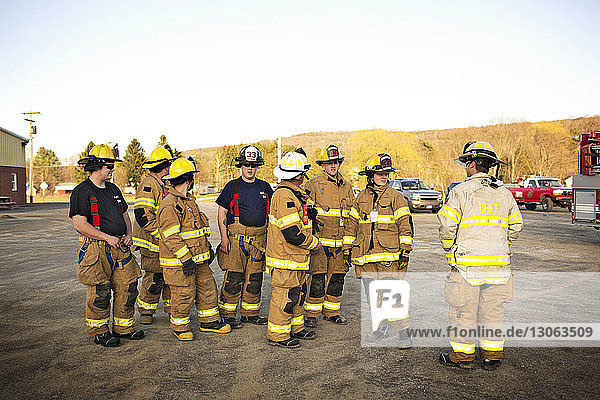 Feuerwehrleute stehen bei der Feuerwache gegen klaren Himmel