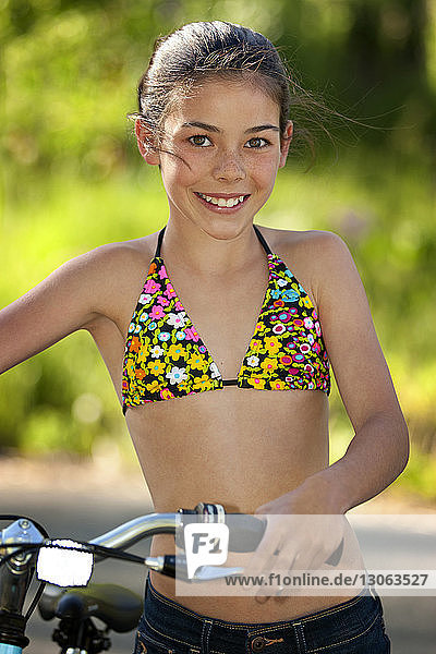 Porträt eines auf der Strasse stehenden Mädchens mit Fahrrad