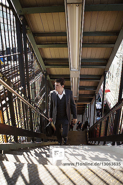 Geschäftsmann beim Treppensteigen am Bahnhof