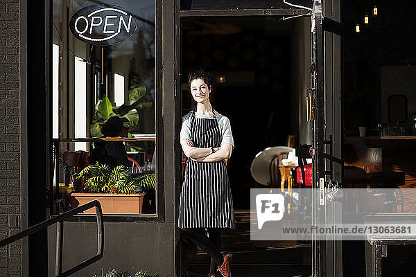 Portrait of cafe owner standing at entrance