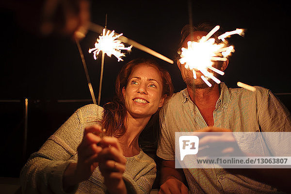 Couple holding sparklers at night