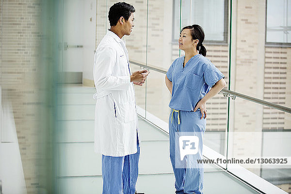 Doctors discussing while standing in hospital