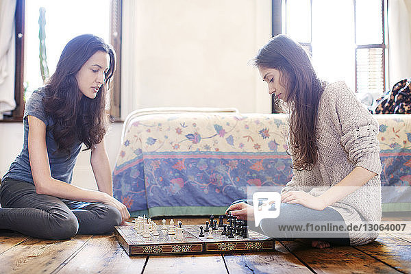 Sisters playing chess at home