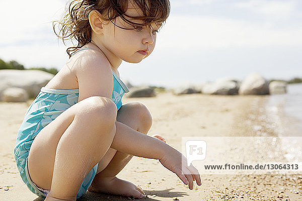 Side view of girl playing on shore at beach